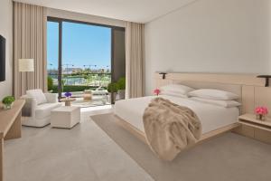 The Jeddah EDITION في جدة: غرفة نوم بيضاء مع سرير وغرفة معيشة