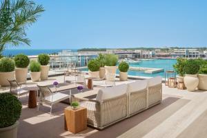 a rooftop patio with chairs and tables and a view of the water at The Jeddah EDITION in Jeddah