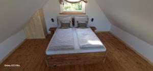 a wooden bed in a room with a window at W ładnym polu n1 in Ruciane-Nida