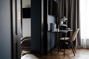 een zwarte kamer met een kleine tafel en stoelen bij The Nox Hotel in Utrecht