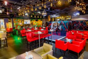 un ristorante con sedie e tavoli rossi di Fortune Pearl Hotel a Dubai