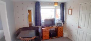 Habitación con escritorio, ordenador y TV. en Home and Away Guesthouse, en Bridlington