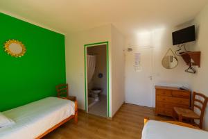 Dormitorio verde con cama y espejo en Hôtel La Barguelonne en Montcuq