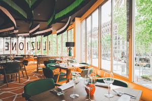 a restaurant with tables and chairs and windows at Hesperia Barcelona Presidente in Barcelona