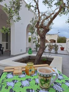 a table with a cup of coffee and a tree at Casa Azzurra - Casa dell'Ulivo in Triscina