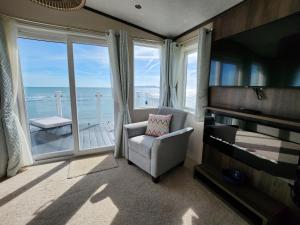 a living room with a chair and a large window at Pemberton Avon pitch 30 Creek Caravan Park dog friendly in Ringstead +43 photos