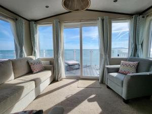 a living room with a couch and chairs and the ocean at Pemberton Avon pitch 30 Creek Caravan Park dog friendly in Ringstead