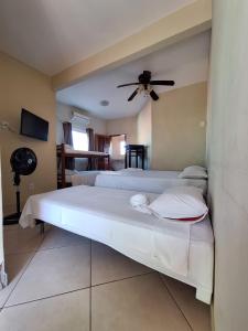 a bedroom with two beds and a ceiling fan at Hospedagem Recanto dos Anjos in Arraial do Cabo