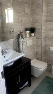 a bathroom with a sink and a toilet at Newly Renovated 2 bed Apartment - Kingston Estate in Ballito