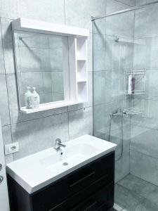 een badkamer met een wastafel en een douche bij Apartment Olive in Dhërmi