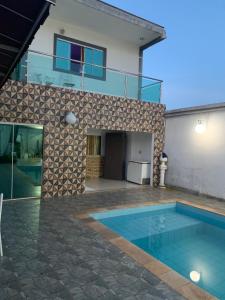 a house with a swimming pool in front of a house at Casa Branca in Londrina