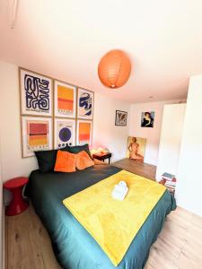 a bedroom with a bed with a yellow blanket on it at Appartement cosy proche Disneyland et Paris in Nanteuil-lès-Meaux