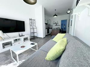 een woonkamer met een bank en een flatscreen-tv bij Apartment Olive in Dhërmi