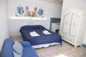 a bedroom with a blue bed and a blue couch at Residence Casale Verderame in Trapani +85 photos
