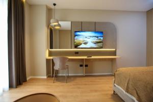 a hotel room with a television and a bed at Regina Palm Resort in Orikum