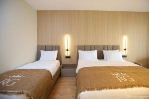 two beds sitting next to each other in a room at Regina Palm Resort in Orikum