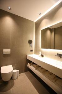 a bathroom with a toilet and a sink and a mirror at Regina Palm Resort in Orikum