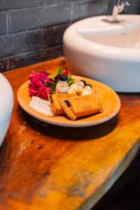 un plato con flores y jabón y un fregadero en Vila de Taipa Exclusive Hotel, en Japaratinga