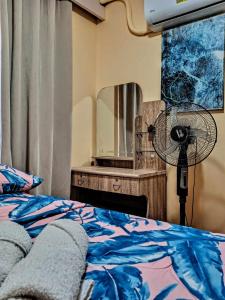 a bedroom with a bed with a fan and a mirror at Sanremo Oasis Unit 1104 in Talisay