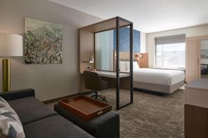 SpringHill Suites by Marriott Avon Vail Valley في آفون: غرفة في الفندق مع أريكة وسرير ومرآة