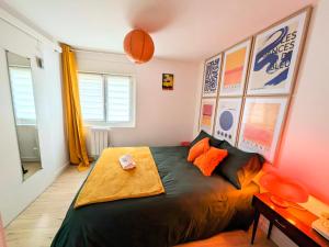 a bedroom with a large bed with orange pillows at Appartement cosy proche Disneyland et Paris in Nanteuil-lès-Meaux