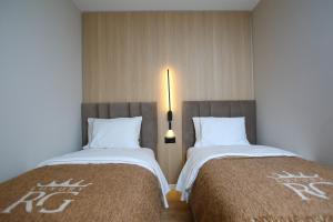 two beds sitting next to each other in a room at Regina Palm Resort in Orikum