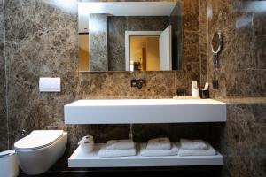 a bathroom with a sink and a toilet and a mirror at Regina Palm Resort in Orikum