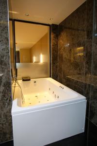 a bath tub in a bathroom with a large mirror at Regina Palm Resort in Orikum