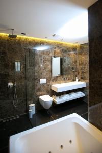 a bathroom with a tub and a sink and a mirror at Regina Palm Resort in Orikum