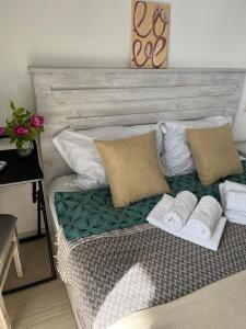 uma cama com almofadas e toalhas por cima em Junona em Makhinjauri