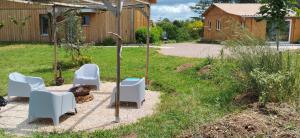 un jardín con sillas blancas y sombrilla en Eden 122, en Albi