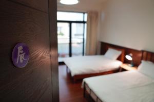 Rúm í herbergi á Chenting Yiyu B&B