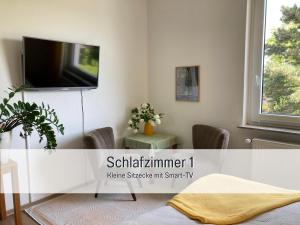a living room with a tv on a wall at Ferienwohnung am Maximilianpark Hamm in Hamm