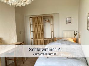 a bedroom with a bed and a table and a chandelier at Ferienwohnung am Maximilianpark Hamm in Hamm
