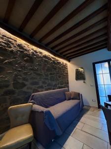 1 dormitorio con cama y pared de piedra en Antico olivo, en Tuoro sul Trasimeno