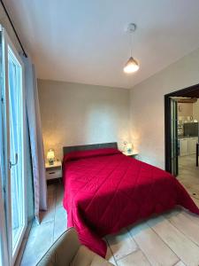 1 dormitorio con 1 cama con edredón rojo en Antico olivo, en Tuoro sul Trasimeno
