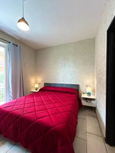 1 cama roja en un dormitorio con 2 mesitas de noche en Antico olivo, en Tuoro sul Trasimeno