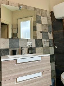 La salle de bains est pourvue d'un lavabo et d'un miroir. dans l'établissement Antico olivo, à Tuoro sul Trasimeno