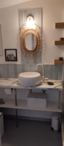 La salle de bains est pourvue d'un lavabo et d'un miroir mural. dans l'établissement Eden 122, à Albi