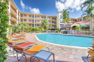 una fila de tumbonas junto a una piscina en un hotel en Holiday Inn & Suites Boca Raton - North, en Boca Raton