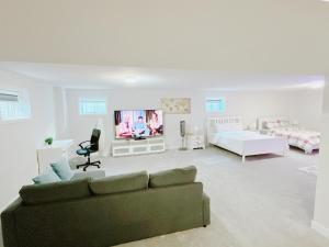 een woonkamer met een bank en een tv bij Beautiful entire basement with Netflix in Stittsville