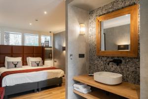 um quarto com uma cama, um espelho e um lavatório em Badhotel Rockanje em Rockanje