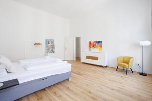 Un dormitorio blanco con una cama y una silla. en 4ty3 Apartments - Stadtpark City Apartment is calling, en Viena 11 fotos más
