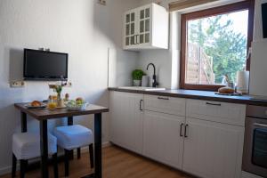 a kitchen with a small table and a window at Ferienhof Kruse Wohnung 4 in Grömitz