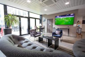 TV a/nebo společenská místnost v ubytování Campanile Belfort Montbéliard - Gare La Jonxion.