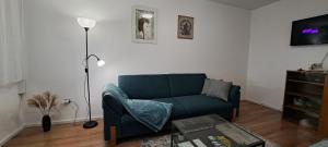 sala de estar con sofá azul y mesa en Apartman Moonlite en Čakovec