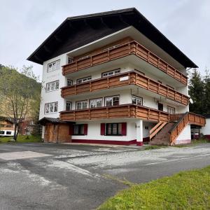 a building with wooden balconies on the side of it at Hillside One - Ski-In Ski-Out Apartments am Arlberg in Warth am Arlberg