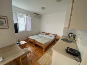MY BUDVA APART في بودفا: مطبخ صغير مع سرير في الغرفة