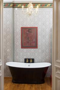 a bath tub in a bathroom with a painting at Vila Katharina in Braşov