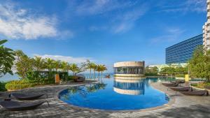 Klandasan Kecil的住宿－Apartemen Borneo Bay City (1 Bedroom Studio)，一座带椅子的度假游泳池以及一座建筑